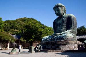 Praying before Daibutsu (Big Buddha) statue at Kotokuin Temple in Kamakura, Japan.