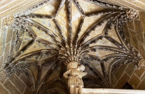 A historic sculpture of a man collecting mustard plants from a stairwell in Dijon.