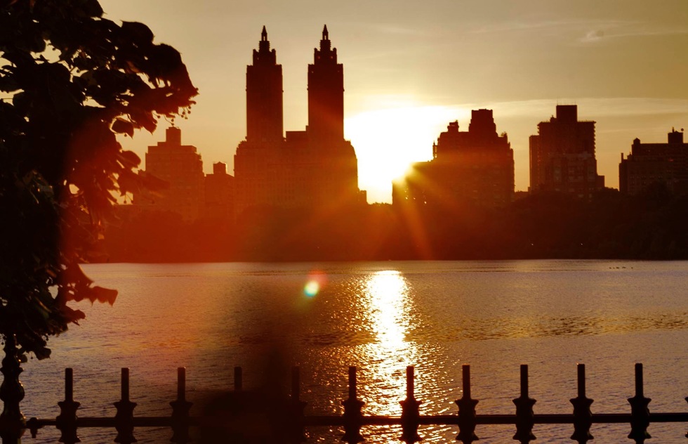 The sun sets over the reservoir in Central Park, New York City